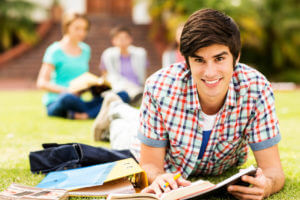 Happy teen boy studying and smiling