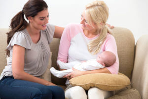 two women with a newborn baby