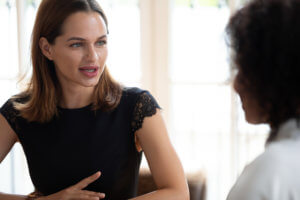 Head shot pleasant young female company owner leader conducting business meeting with mixed race partner. Skilled focused hr manager holding job interview with african american applicant at office.
